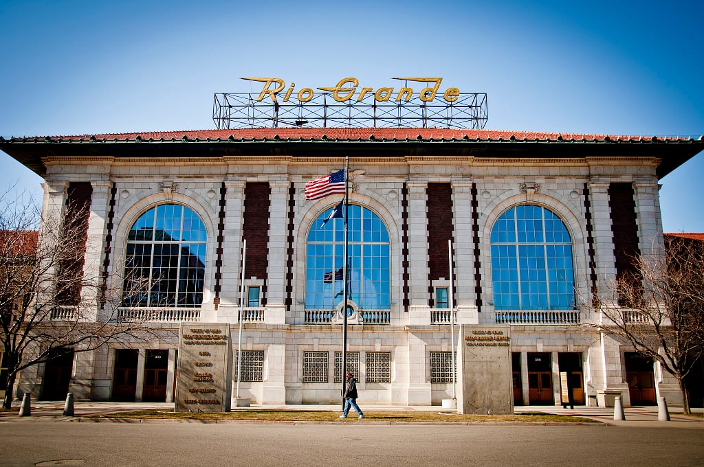 Brick and white building with tall American flag in front, yellow Rio Grande sign on top