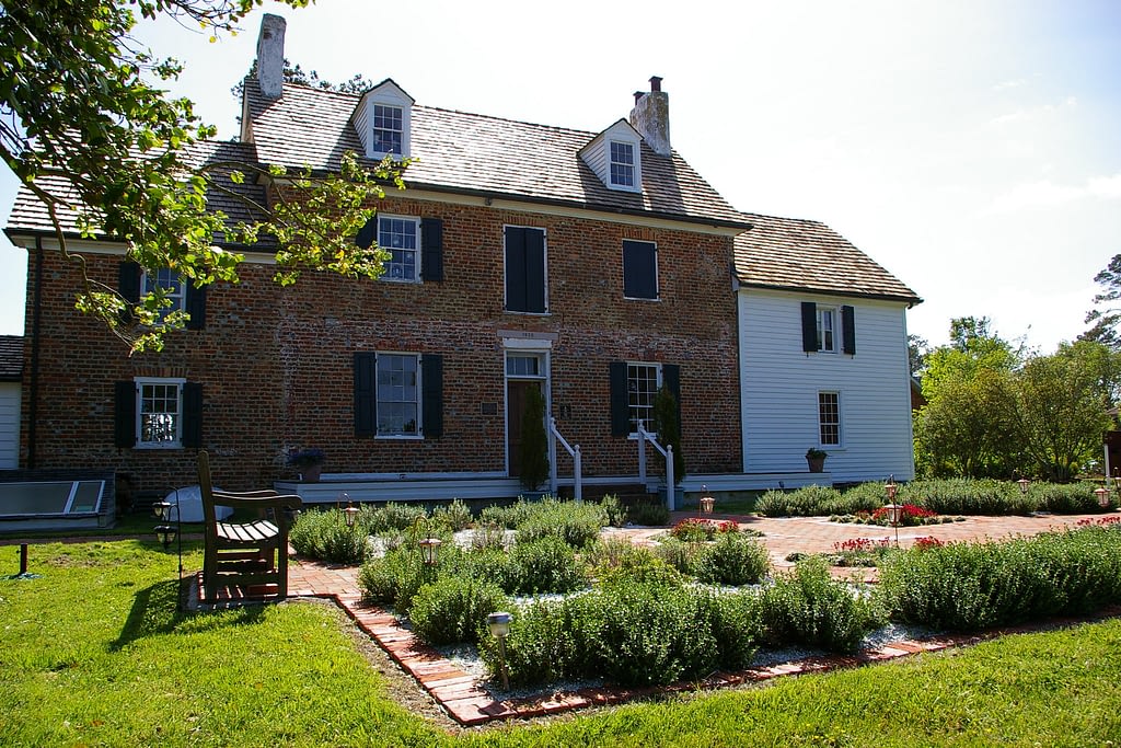 Brick house with small garden in the front with bench