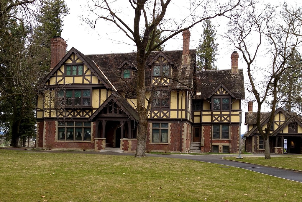 House made of brick with yellow paneling and brown roof