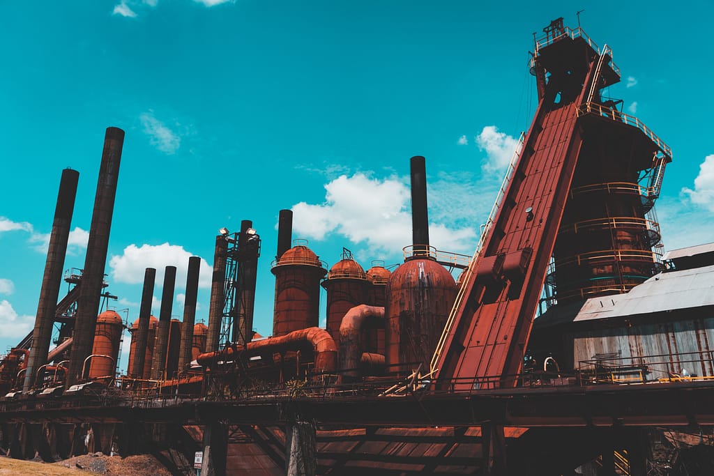 Large red furnaces against blue sky with white clouds