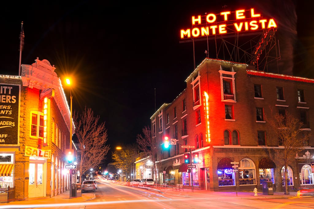 Neon sign that reads Hotel Monte Vista, street scene at night