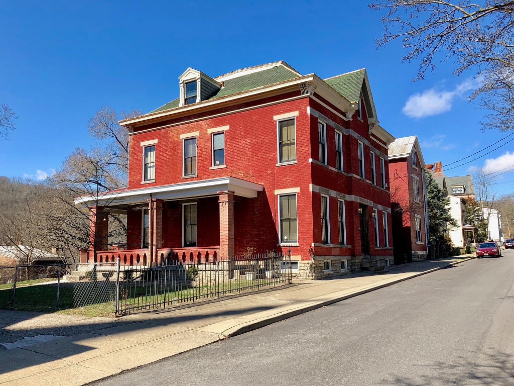 Bright red building with green roof on a street