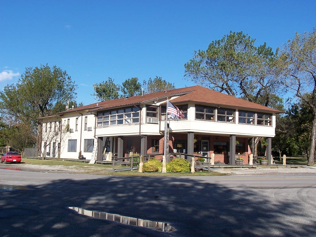 White and brown building with American flag out front