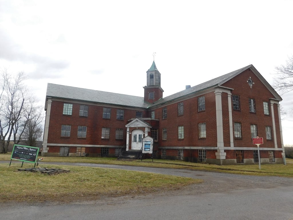 Red brick building with white doors, cloudy sky