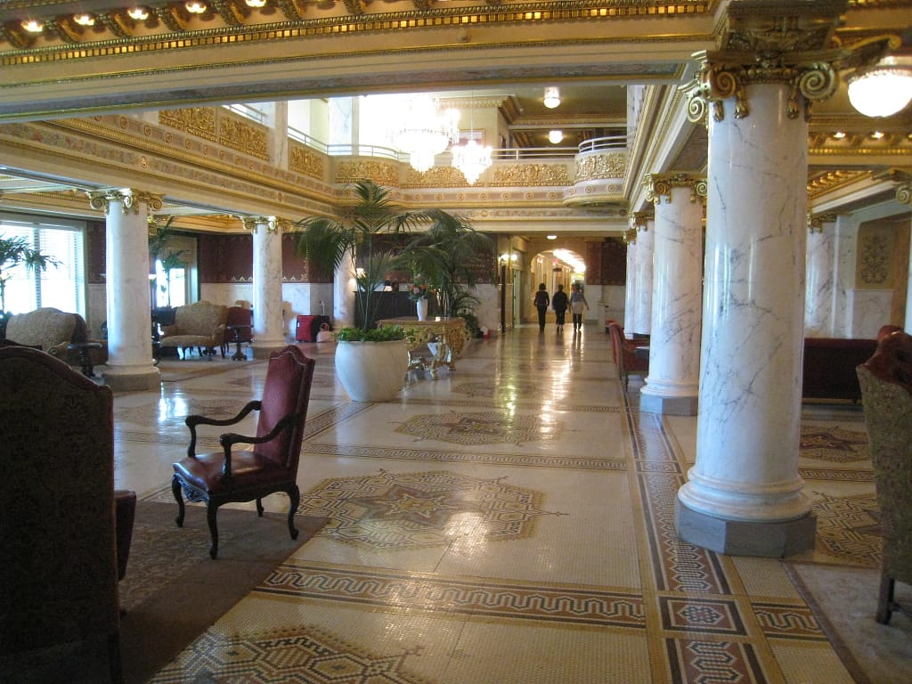 Inside of hotel lobby with white and gold decor