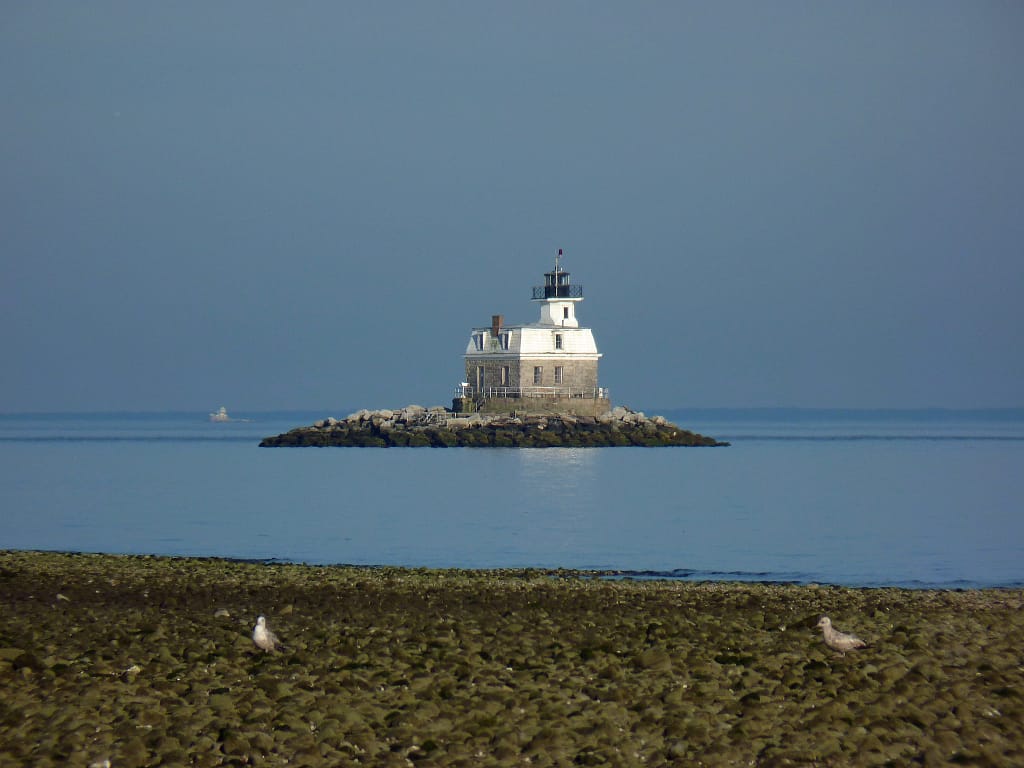 Small white/tan lighthouse on small island